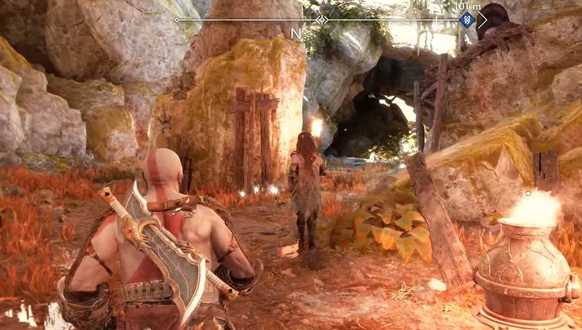 A screenshot of Kratos walking through a mountainous area in God of War: Ragnarok
