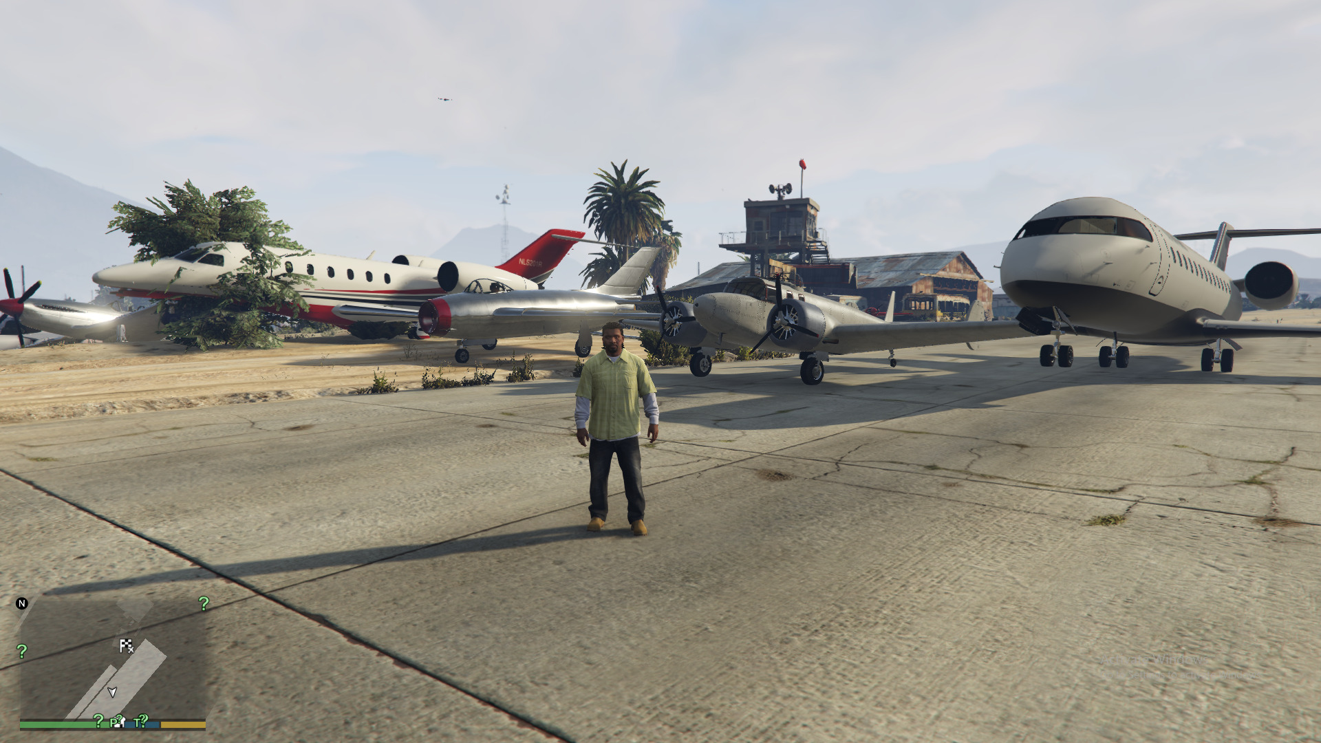 A screenshot of Franklin standing in front of planes in GTA 5